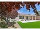 Spacious backyard featuring a covered patio, lush lawn, and mature trees creating a private oasis at 2297 Aria Dr, Henderson, NV 89052