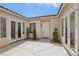 Cozy courtyard with a white front door, tiled roof, and desert landscaping at 2297 Aria Dr, Henderson, NV 89052