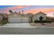 Charming home featuring a three-car garage and desert landscaping at sunset at 2297 Aria Dr, Henderson, NV 89052