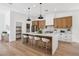The chef's kitchen features a large island with seating, stainless steel appliances, and designer lighting at 2297 Aria Dr, Henderson, NV 89052