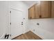 Well-lit laundry room with overhead cabinets, a white door, and vinyl flooring at 2297 Aria Dr, Henderson, NV 89052