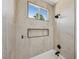 A beautifully tiled shower and bathtub combination with black finish plumbing fixtures and a window at 2297 Aria Dr, Henderson, NV 89052