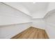Walk-in closet features custom white shelving and laminate wood-look flooring at 2297 Aria Dr, Henderson, NV 89052