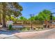 Community entrance with brick and white fence, landscaping, and decorative lamps and street sign at 2770 La Casita Ave, Las Vegas, NV 89120