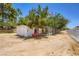 Exterior view of the property with a white storage building, dog kennel, and mature trees at 2770 La Casita Ave, Las Vegas, NV 89120
