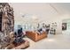 Open-concept living room with a stone fireplace, tan leather furniture and access to the kitchen at 2770 La Casita Ave, Las Vegas, NV 89120