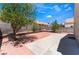Large backyard featuring a tiled patio area, a tree, and block wall fencing at 309 Clifton Heights Dr, Las Vegas, NV 89145