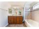 Bright bathroom featuring a double sink vanity with granite countertop, tiled floors, and shower-tub at 309 Clifton Heights Dr, Las Vegas, NV 89145