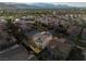 An aerial view showcases a lush residential neighborhood with neatly arranged houses and palm trees against a mountain backdrop at 323 Harpers Ferry Ave, Las Vegas, NV 89148