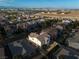 A high angle aerial view shows a residential neighborhood with palm trees and the Las Vegas skyline in the background at 323 Harpers Ferry Ave, Las Vegas, NV 89148
