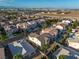 A high angle aerial view shows a residential neighborhood with palm trees and the Las Vegas skyline in the background at 323 Harpers Ferry Ave, Las Vegas, NV 89148