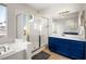 Modern bathroom featuring a walk-in shower, soaking tub, white countertop and a blue vanity at 323 Harpers Ferry Ave, Las Vegas, NV 89148