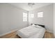 Bedroom featuring a ceiling fan, wood flooring, and natural light from the large windows at 323 Harpers Ferry Ave, Las Vegas, NV 89148