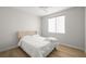 Neutral bedroom features wood floors, a ceiling fan, and a cozy bed with white bedding at 323 Harpers Ferry Ave, Las Vegas, NV 89148