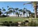 A vibrant Rhodes Ranch community sign is surrounded by manicured lawns, mature palm trees, and lush green bushes at 323 Harpers Ferry Ave, Las Vegas, NV 89148