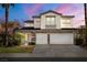 Charming two-story home featuring a three-car garage, stone accents, and beautifully landscaped front yard at 323 Harpers Ferry Ave, Las Vegas, NV 89148