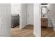 Hallway view to the laundry room and bathroom with wood-look floors at 323 Harpers Ferry Ave, Las Vegas, NV 89148