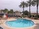 Inviting community pool surrounded by palm trees, landscaping and patio furniture at 3425 E Russell Rd # 265, Las Vegas, NV 89120
