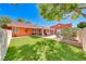 Lush backyard with artificial turf, covered patio, and vibrant landscaping at 4045 N Chieftain St, Las Vegas, NV 89129