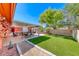 Well-maintained backyard with a covered patio, lawn, and mature trees at 4045 N Chieftain St, Las Vegas, NV 89129