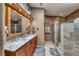 Well-lit bathroom featuring double sinks, marble countertops, decorative mirrors and a stone shower stall at 4045 N Chieftain St, Las Vegas, NV 89129