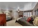 Comfortable bedroom featuring a bed, ceiling fan, plantation shutters, sitting area and natural light at 4045 N Chieftain St, Las Vegas, NV 89129