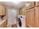 Well-lit laundry room with cabinetry, modern appliances, and exterior access door at 4045 N Chieftain St, Las Vegas, NV 89129