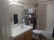 Standard bathroom featuring a toilet, shower-tub, sink with white counter, and metal storage shelving at 424 Wright Way, Henderson, NV 89015