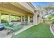 Charming backyard with a covered patio, putting green, and a built-in grill for easy outdoor entertaining at 4636 Riva De Romanza St, Las Vegas, NV 89135