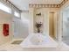 Bright bathroom featuring a large soaking tub, glass enclosed shower, and decorative accents at 4636 Riva De Romanza St, Las Vegas, NV 89135