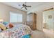 Inviting bedroom with large window, ceiling fan, and bathroom access through a decorative doorway at 4636 Riva De Romanza St, Las Vegas, NV 89135
