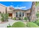 Stunning front entrance with beautiful archways, manicured landscaping, and decorative details at 4636 Riva De Romanza St, Las Vegas, NV 89135