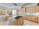 Expansive kitchen with granite countertops, light wood cabinets, and open access to dining area at 4636 Riva De Romanza St, Las Vegas, NV 89135