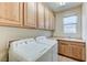 Clean laundry room features a sink, tile floors, and custom cabinets at 4636 Riva De Romanza St, Las Vegas, NV 89135