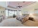 Spacious main bedroom with a cozy sitting area near a large window and a patterned ceiling fan at 4636 Riva De Romanza St, Las Vegas, NV 89135