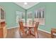 Bright dining area with wood table, six chairs, and natural light from two large windows at 4724 Stavanger Ln, Las Vegas, NV 89147