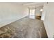 Bright living room with plush carpet, a ceiling beam, and glass sliding doors at 4924 Carmen Blvd, Las Vegas, NV 89108