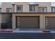 Contemporary townhome facade featuring a clean design, individual garages and a manicured landscape at 494 Mahogany Ridge St, Las Vegas, NV 89138
