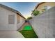 Narrow backyard space including an artificial green and partial privacy wall at 528 Lavina Ct, Las Vegas, NV 89123