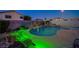 Lush backyard featuring a custom-shaped pool with a rock waterfall and colorful garden lighting at 528 Lavina Ct, Las Vegas, NV 89123
