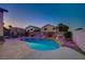 Beautiful backyard oasis with a custom pool, rock waterfall, and vibrant landscape lighting at 528 Lavina Ct, Las Vegas, NV 89123