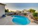 Beautiful backyard pool area with rock accents and lush landscaping providing a serene and private outdoor retreat at 528 Lavina Ct, Las Vegas, NV 89123