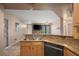 Open concept kitchen with stone countertops and black appliances flowing into the living room at 5855 Valley Dr # 2130, North Las Vegas, NV 89031