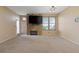 Spacious carpeted living room featuring a fireplace, a ceiling fan and natural light from the window at 5855 Valley Dr # 2130, North Las Vegas, NV 89031