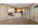 Open-concept living room with the kitchen area in the background. Neutral colors throughout at 5855 Valley Dr # 2130, North Las Vegas, NV 89031