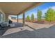 Covered patio area that overlooks a spacious backyard with desert landscaping and mature trees at 5953 Yellow Ridge Ave, Las Vegas, NV 89131