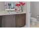 Close up of bathroom vanity and toilet with red flower accent at 5953 Yellow Ridge Ave, Las Vegas, NV 89131