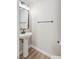Modern powder room featuring a pedestal sink, black hardware and fixtures, and neutral decor at 6525 Raven Hall St, North Las Vegas, NV 89084