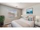 Staged bedroom with natural light, neutral tones, and modern decor at 6525 Raven Hall St, North Las Vegas, NV 89084