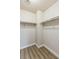 Walk-in closet features white walls, wood-look flooring, and rod for hanging clothes at 6525 Raven Hall St, North Las Vegas, NV 89084